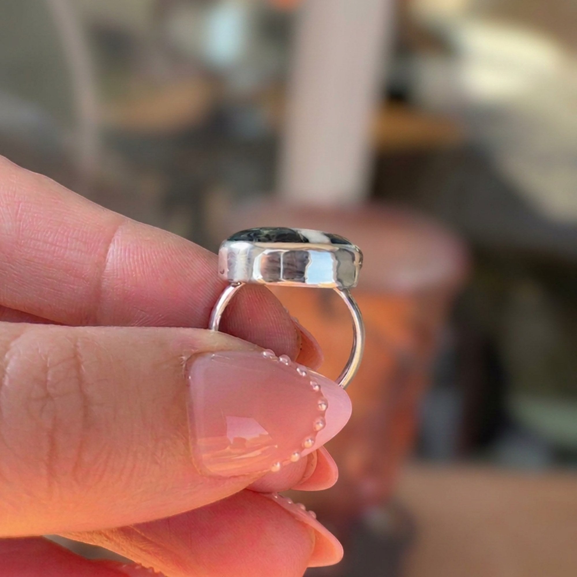 Wildflower Artisans sterling silver ring featuring a natural White Buffalo stone with charcoal veining, side view