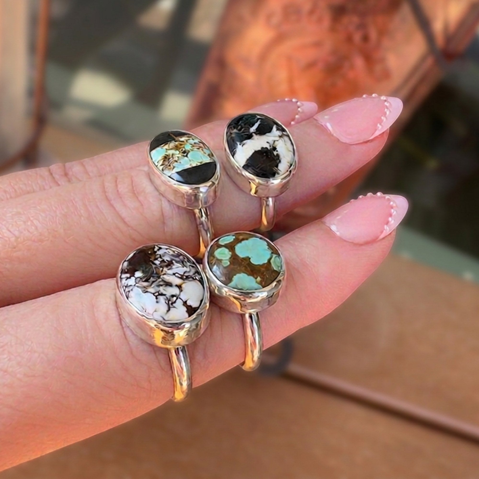 Wildflower Artisans sterling silver rings featuring oval Wild Horse magnesite and hematite stones on a hand