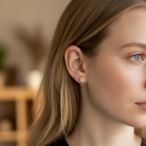 Wildflower Artisans yellow opal stud earrings in 14K gold worn by a woman with blonde hair