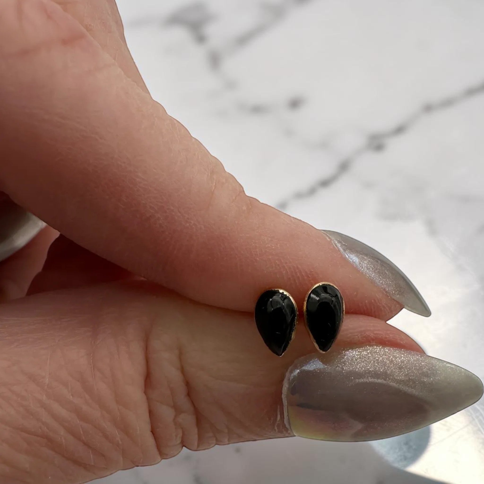 Wildflower black onyx teardrop stud earrings in 24K gold bezel. Pear-shaped polished onyx.