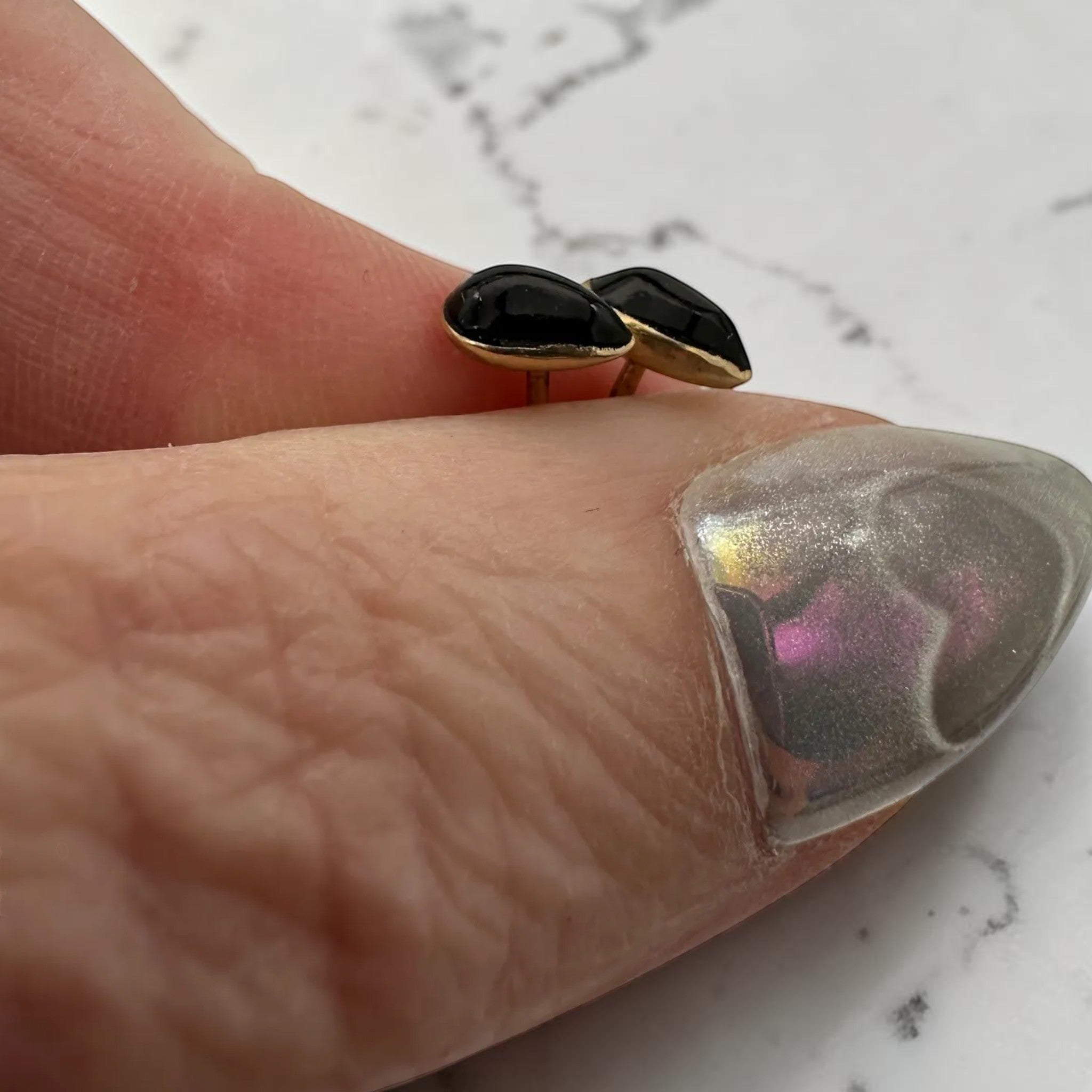 Wildflower black onyx teardrop stud earrings in 24K gold bezel, approximately 7x5mm.