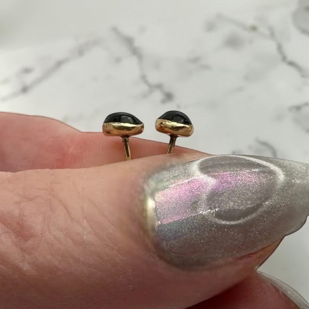 Wildflower black onyx teardrop stud earrings in 24K gold bezel. Pear-shaped polished onyx.