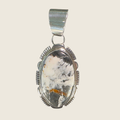 White buffalo pendant necklace in Navajo sterling silver by Leslie Yazzie, shown on a bone linen background