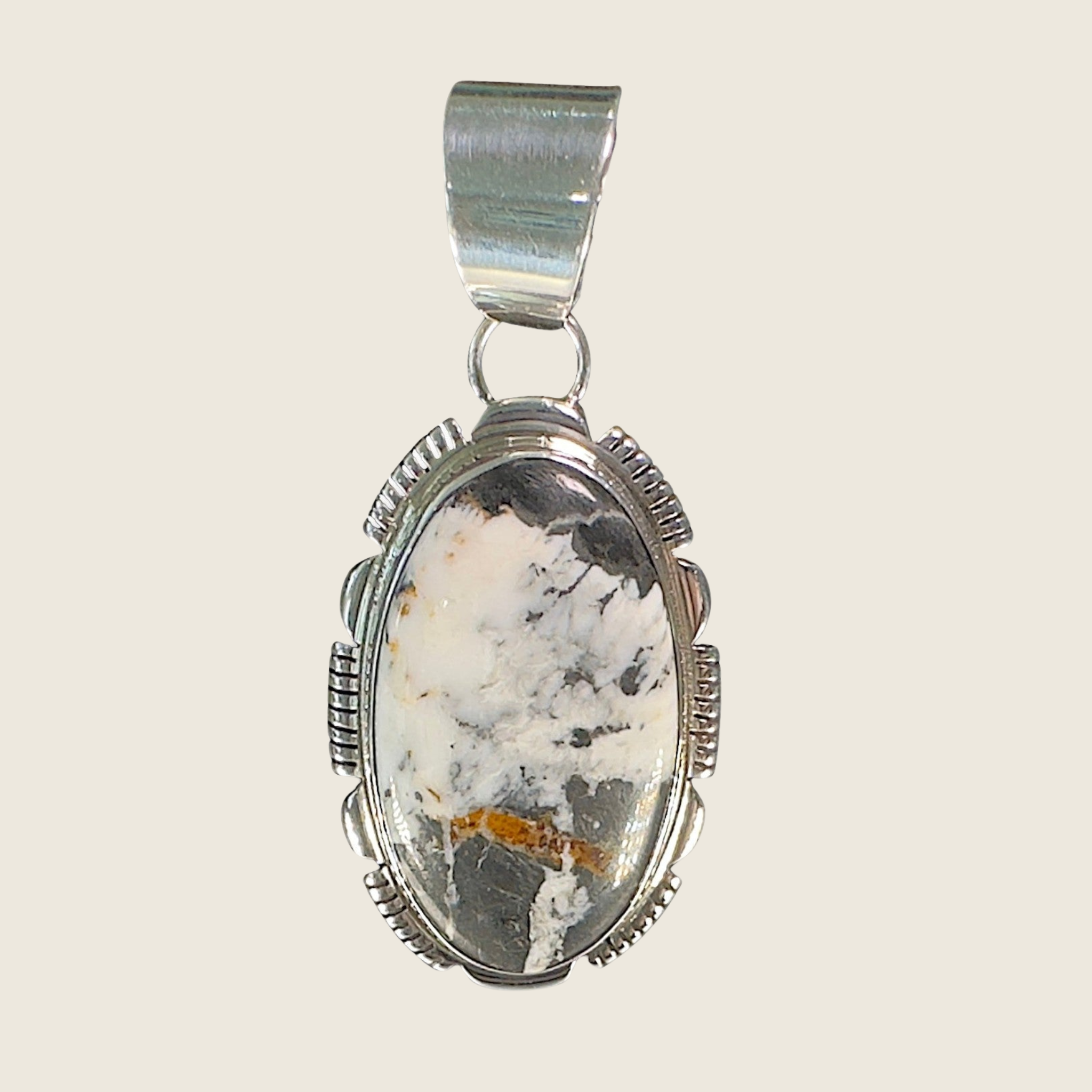 White buffalo pendant necklace in Navajo sterling silver by Leslie Yazzie, shown on a bone linen background